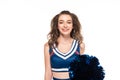 Happy cheerleader girl in blue uniform holding pompoms and looking at camera isolated on white