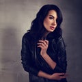 long black hairstyle woman posing in fashion black leather jacket on dark studio background
