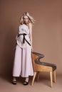 luxurious woman in a dress sitting on a chair. Autumn collection of women clothing. Fashion blonde in a long beautiful dress Royalty Free Stock Photo