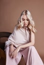 luxurious woman in a dress sitting on a chair. Autumn collection of women clothing. Fashion blonde in a long beautiful dress Royalty Free Stock Photo