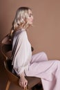 luxurious woman in a dress sitting on a chair. Autumn collection of women clothing. Fashion blonde in a long beautiful dress Royalty Free Stock Photo