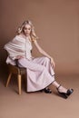 luxurious woman in a dress sitting on a chair. Autumn collection of women clothing. Fashion blonde in a long beautiful dress Royalty Free Stock Photo