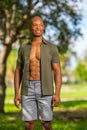 Sexy male model posing in the park with shirt unbuttoned showing muscle chest Royalty Free Stock Photo