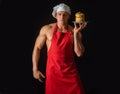 Sexy man in chefs hat with sweet homemade stack of pancakes with syrup isolated on black. Chef muscle man with apron