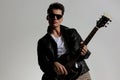 sexy man in leather jacket playing guitar and enjoying music Royalty Free Stock Photo
