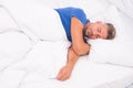 Sexy man lying on bed with soft pillows at home. Perfect morning. Tips sleeping better. male health. Enjoying time at Royalty Free Stock Photo