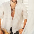 Sexy man model body dressed in white shirt with jewelry