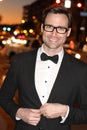 man in tuxedo and bow tie posing in the city streets at night Royalty Free Stock Photo