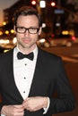man in tuxedo and bow tie posing in the city streets at night Royalty Free Stock Photo