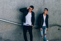 mans posing near railing. Handsome young mans in stylish black clothes and white shoes posing near a railing. friendship Royalty Free Stock Photo