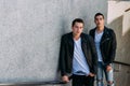 Sexy mans posing near railing. Handsome young mans in stylish black clothes and white shoes posing near a railing. friendship Royalty Free Stock Photo