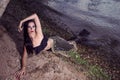 Sexy Mermaid Posing With Net Near Sea on Rocks While Wearing Artistic Makeup and Black Shiny Tail Covered With Colorful Spangles