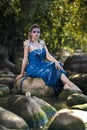 Sexy Mermaid of Sea in Artistic Caucasian Blond Woman With Strasses on Face Sitting in Blue Wet Dress on Rocky Shore Outdoor