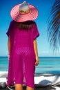 model girl in colorful cloth and sunhat behind blue beach Royalty Free Stock Photo