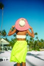 model girl in colorful cloth and sunhat behind blue beach Royalty Free Stock Photo