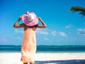 model girl in colorful cloth and sunhat behind blue beach Royalty Free Stock Photo