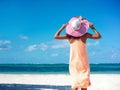 model girl in colorful cloth and sunhat behind blue beach Royalty Free Stock Photo