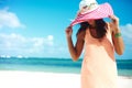 model girl in colorful cloth and sunhat behind blue beach Royalty Free Stock Photo