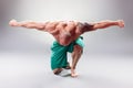 Sexy Muscular bodybuider kneeling and posing on the gray background