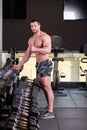 Sexy muscular man holding dumbbels and prepares for exercise. Looking at camera. Thumb up