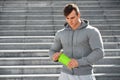 muscular man holding shaker, outdoors. Young active male drinking water