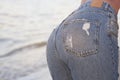 perfect woman in jeans against the sea. back view. Middle body parts. Fashion. Advertising of fashionable jeans.