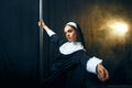 Sexy perverse nun in a cassock dances on a pole