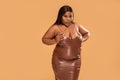 Sexy Plus Size african Woman posing in brown leather dress, looking at the camera. Fashionable girl. Body positive and conscious Royalty Free Stock Photo