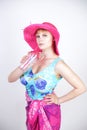 Sexy plus size girl in a blue swimsuit, fuchsia hat with brim and in a trendy bright pareo stands on a white background in the Stu Royalty Free Stock Photo