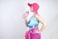 Sexy plus size girl in a blue swimsuit, fuchsia hat with brim and in a trendy bright pareo stands on a white background in the Stu Royalty Free Stock Photo