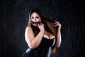 Sexy plus size model in black corset, fat woman with big natural breasts on dark background, body positive concept Royalty Free Stock Photo