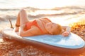 Sexy plus sized smiling woman in red swimsuit lying on sup board at the beach. The concept of surfing and summer Royalty Free Stock Photo