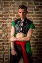 portrait of a very muscular Caucasian male model dancer in national costume against a brick wall Royalty Free Stock Photo