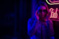 Sexy portrait of a young girl with an open bust in sunglasses and with in the night city, red-blue light of neon lamps. Night Royalty Free Stock Photo