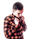 Fashion style portrait of young handsome man in stylish red checkered shirt with hands on his shirt on white background