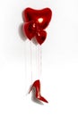 Sexy red high-heeled shoe hangs on red heart-shaped balloons. Valentine\'s day Royalty Free Stock Photo