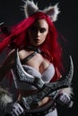 Sexy redhead woman in cosplay costume of warrior cat with swords