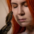 Sexy redhead woman holding snake. close-up photo girl with pygmy python on a white background Royalty Free Stock Photo