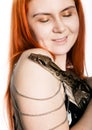 Sexy redhead woman holding snake. close-up photo girl with pygmy python on a white background Royalty Free Stock Photo