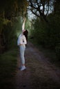 Sexy sensual brunette walks in a summer forest at sunset in a white blouse and jeans Royalty Free Stock Photo