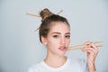 Sexy sensual woman picking lips with chopsticks. Sexy mouth for sushi advertising. Studio isolated portrait. Royalty Free Stock Photo