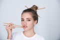 Sexy sensual woman picking lips with chopsticks. Sexy mouth for sushi advertising. Studio  portrait. Royalty Free Stock Photo