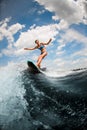 Sexy woman having fun on the board on the river wave against blue sky Royalty Free Stock Photo