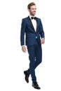 Sexy smiling man in blue tuxedo walking