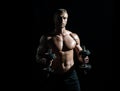 Sexy sporty torso, man with dumbbells. Muscular and strong guy exercising. Sportsman doing exercises with weights