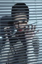 spy woman behind shutters