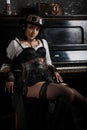 Sexy steampunk girl sitting next to the piano Royalty Free Stock Photo