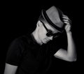 Fashion style portrait of muscular, young handsome man in black t-shirt with stylish hat and modern sunglasses