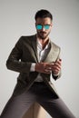 stylish man wearing sunglasses sits on wooden box Royalty Free Stock Photo