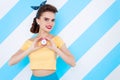 Young retro pinup woman on colorful background